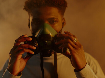 A man, clad in a gas mask, struggles to breathe, a stark symbol of the climate crisis and its dire impact