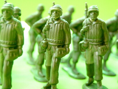 Small plastic soldiers arranged with precision, representing the systemic nature of recruitment and deployment