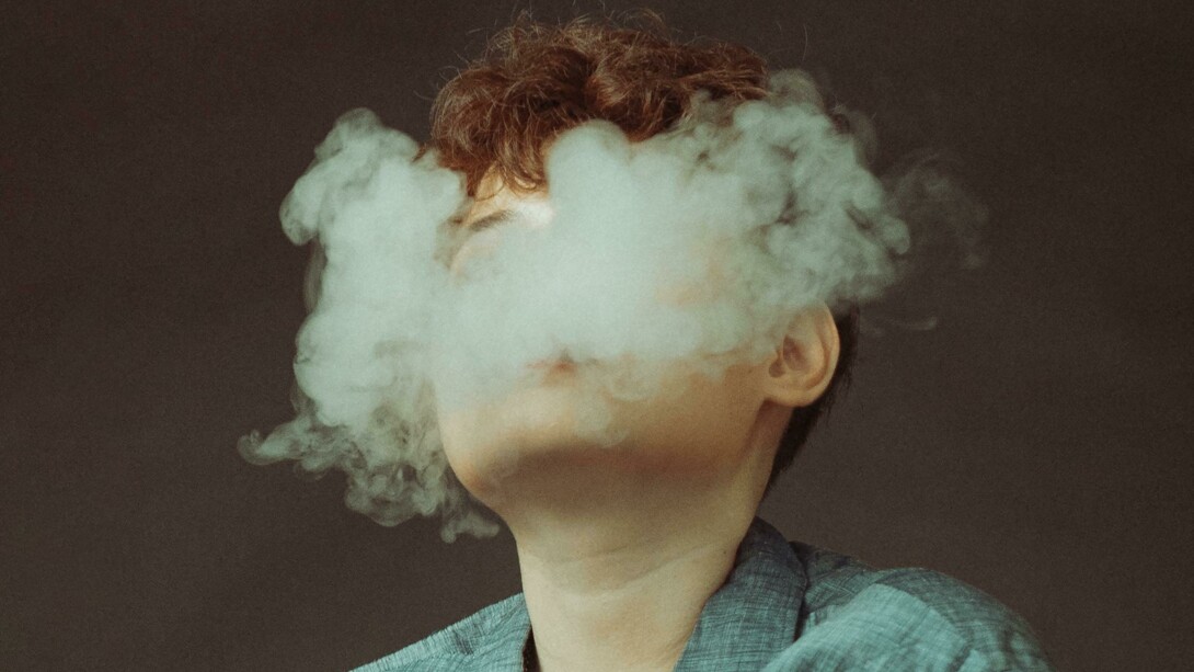 A woman is obscured by a cloud of e-cigarette smoke