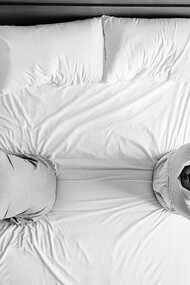 A sad couple sitting back-to-back on the bed, overwhelmed by emotional distress and a broken heart