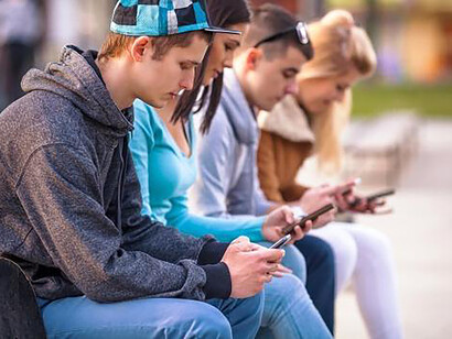 Jeunes gens rivés sur leur smartphone. Cette ressemblance des étudiants des amphithéâtres des universités avec des cyclistes arc-boutés sur leur guidon