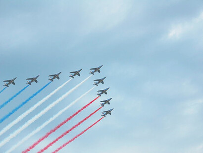 Tricolor smoke trails begin the flyover in France