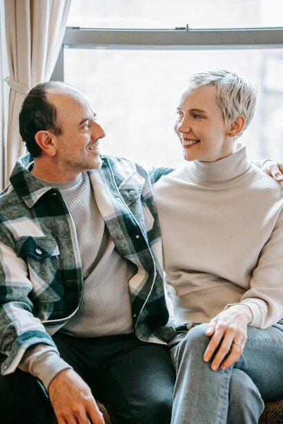 A happy couple relaxing on a couch while enjoying a conversation