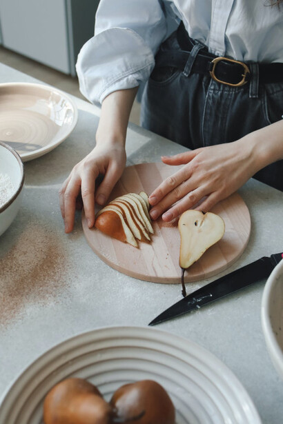 Donna in cucina mentre taglia della frutta 