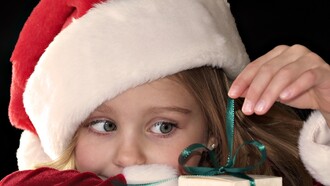 Una pequeña Papa Noel prepara los regalos de Navidad