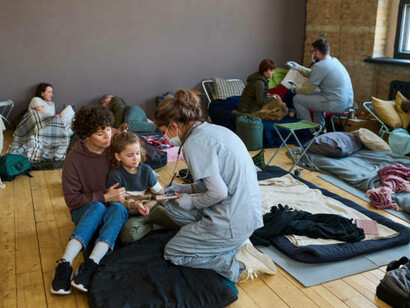 In the shelter, a young woman volunteers to assist refugees