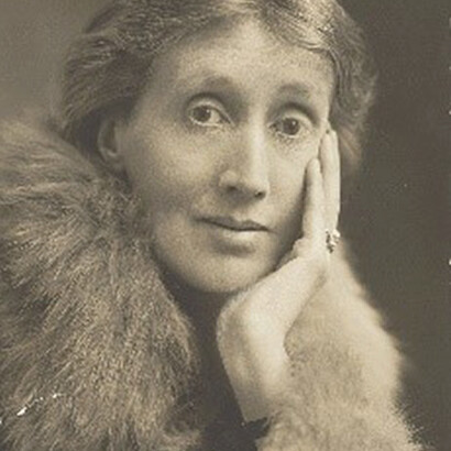 In this captivating photograph, Virginia Woolf is captured with her hand delicately resting on her face, exuding an air of contemplation and sophistication, while elegantly adorned in a fur stole