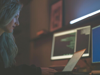 A woman typing on a keyboard in a modern workspace, symbolizing focus and connection in the digital age
