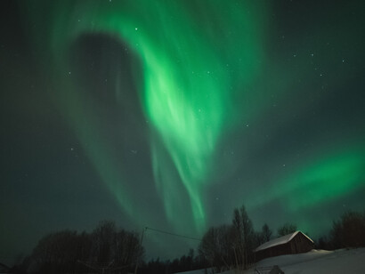 Feixes de luz verde de uma aurora no ápice de seu fenômeno