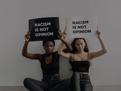 Mulheres seguram cartazes com escrito 'Racismo não é uma opinião'