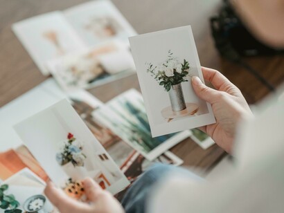 A young woman looking at photos, representing a moment of pause in our fast-moving visual world