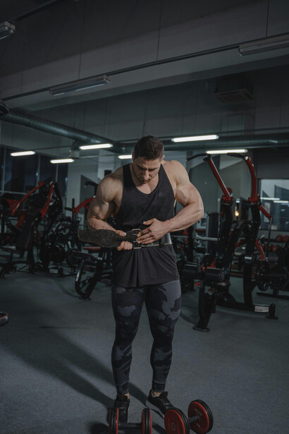 A strong man training with a barbell in a well-lit fitness center