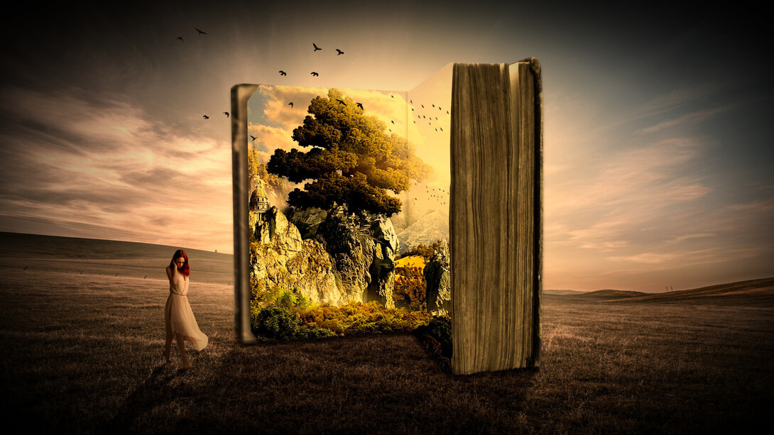 A woman stands next to a large book with a tree inside and birds overhead