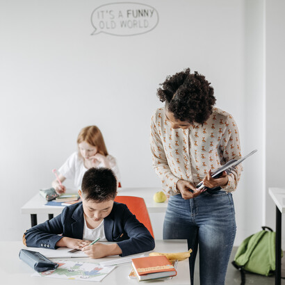 Professora auxilia trabalho de aluno recém chegado de outro país 