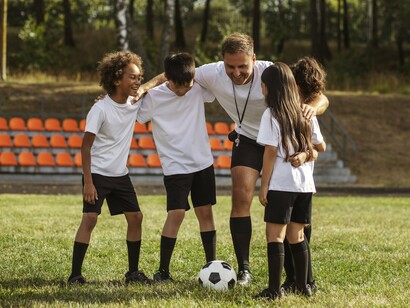 A coach building confidence in young players, representing the foundations of resilience and growth