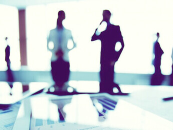 The intricacies of the technology industry's market dynamics, economic growth, and government intervention through a compelling close-up of a financial report, complemented by the backdrop of businesspeople engaged in strategic discussions