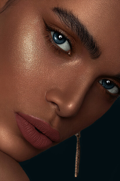 Woman with red lipstick, gold hoop earrings, thick eyebrows, and bronze makeup from the 2010s