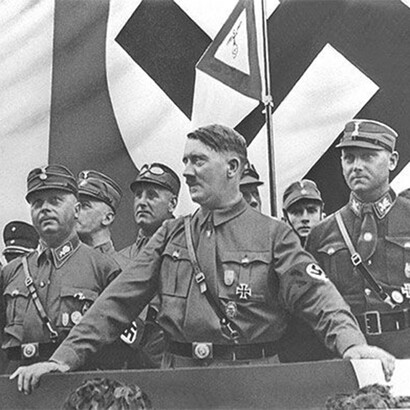 Adolf Hitler, the infamous leader of Nazi Germany, delivering a powerful speech to a massive crowd during a rally in 1933, standing at a raised podium