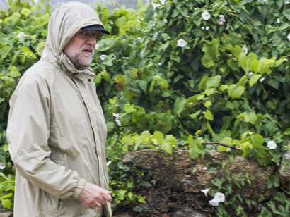 El presidente del gobierno español, Mariano Rajoy, pasea bajo la lluvia