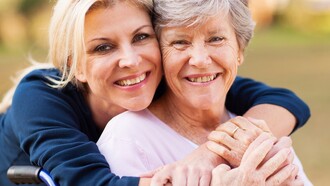 Una mujer abraza a su madre anciana