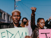 In the midst of a chaotic protest, people converge with a shared sense of urgency, reflecting a collective frustration that often overrides individual critical thinking