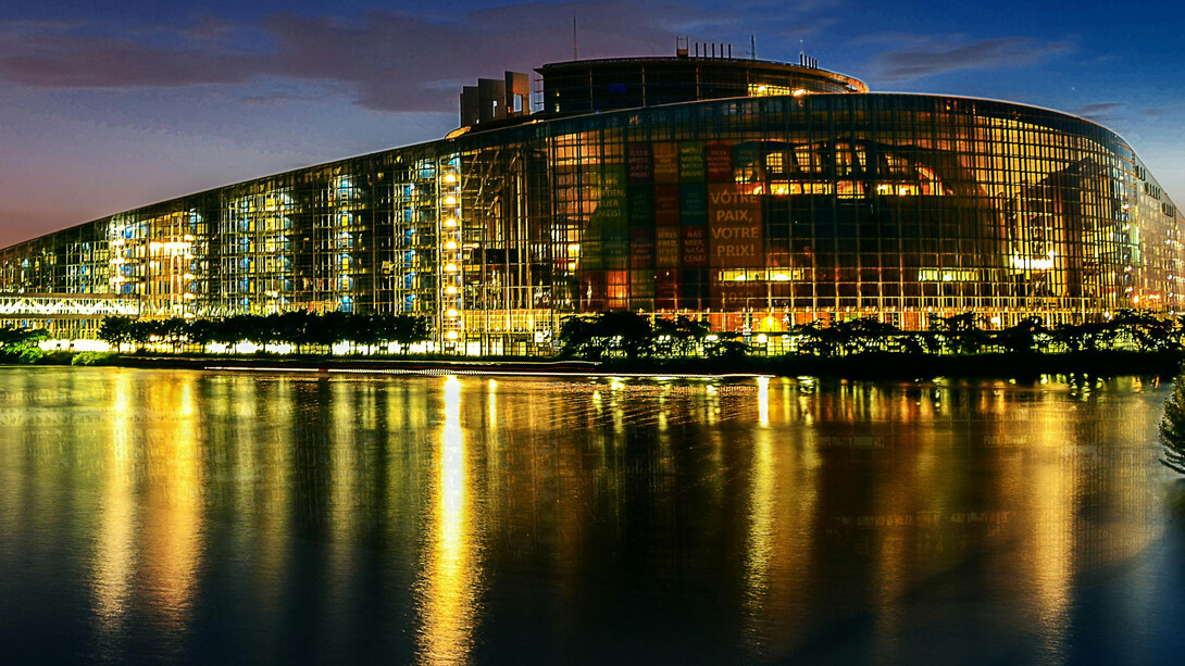The European Union Parliament in Strasbourg, France, illuminated at night beside a body of water