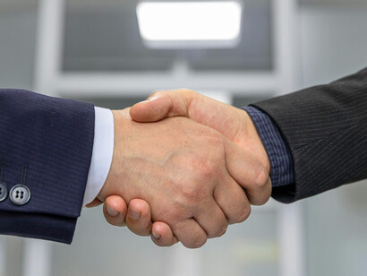 A handshake between two people, a sign of worldwide transactions, characteristic of globalization