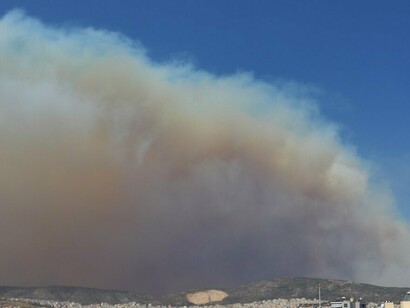 The smoke-filled sky represents the kind of inferno that could be better managed with a decentralized firefighting approach, empowering regions to respond more urgently