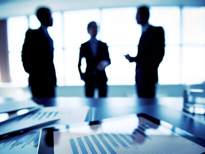 The interplay of economic growth, government intervention, and market dynamics in the technology industry through a captivating close-up of a financial report, featuring a backdrop of businesspeople immersed in strategic discussions