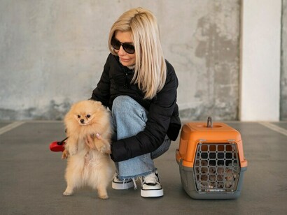 A woman traveling with her cute dog waits at the airport, choosing an animal-friendly airline to ensure her pet’s comfort