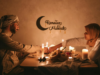 A Muslim couple sharing a candlelit dinner during Ramadan