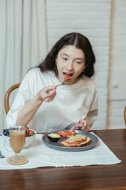 Woman eating a meal with a fork and knife during breakfast
