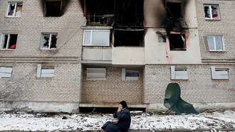 A woman weeps in front of her bombed home in Volnovakha, Ukraine, captured in a photograph by Alexander Ermochenko