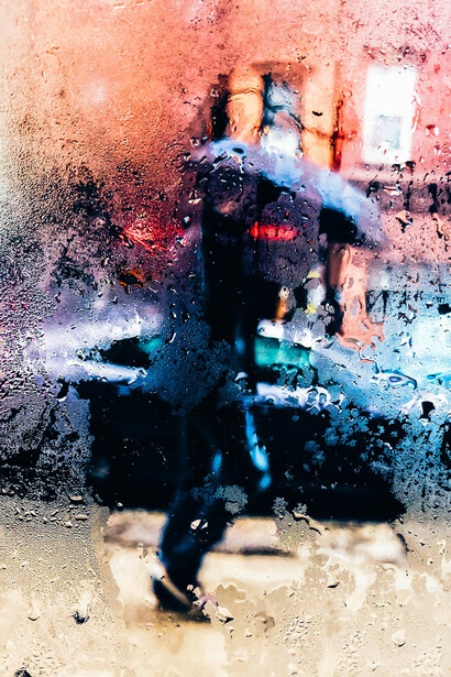 Transeúnte recorre la ciudad bajo la lluvia