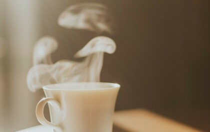 Vapeur s'échappant d'un café servi dans une tasse en porcelaine, peut-être celle d'un hôtel de luxe