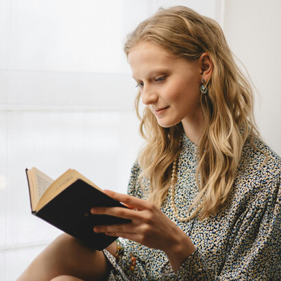 Woman reading a book in a quiet indoor space