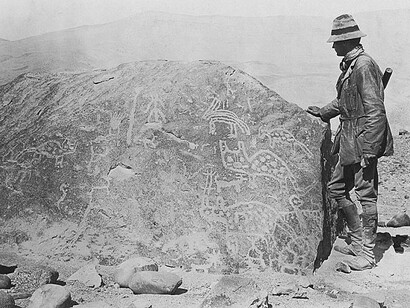 O professor e explorador Hiram Bingham, ao lado de rocha com inscrições incas em Machu Picchu. Foto: National Geographic