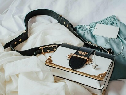A designer bag resting among delicate clothing, reflecting the deeply personal nature of style and self-expression