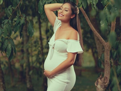Woman smiles and holds her belly