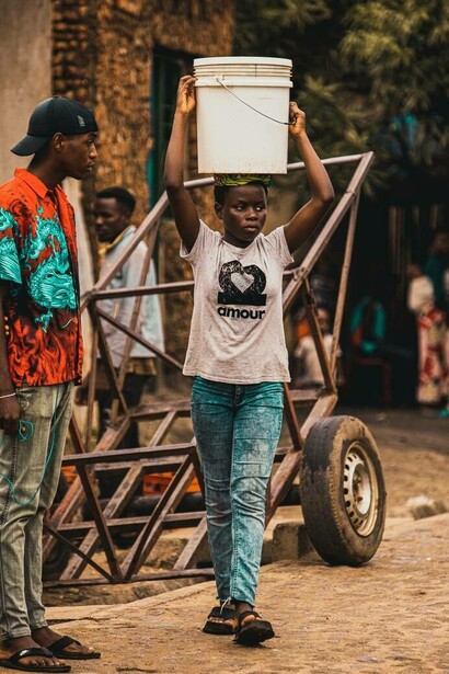Young teen carries a bucket to help serve the community