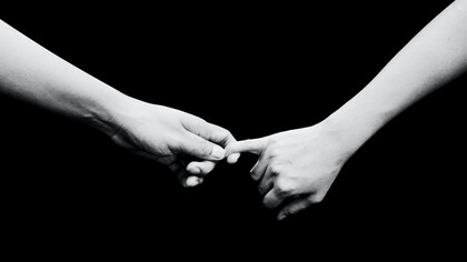 Filho e mãe em momento de adeus ao quase solteram seus dedos