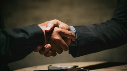 Dos manos estrechándose simboliza el acuerdo voluntario y la base racional del contrato social