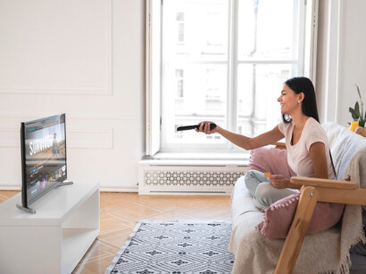 Amidst the growing number of platforms, this woman carefully selects what to watch, navigating the endless options and reflecting the ever-changing landscape of entertainment in the streaming era