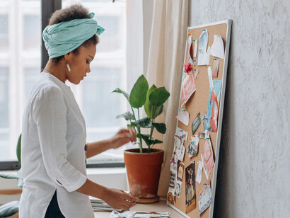 A woman arranges curated lifestyle images into a personal vision board