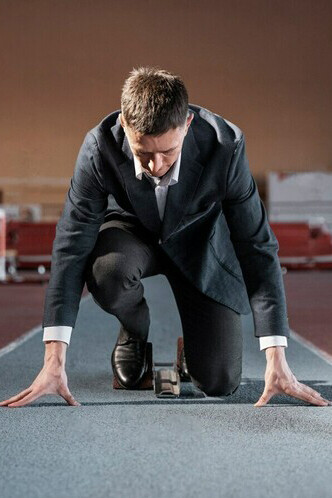 A determined entrepreneur in a suit, poised to take on the coaching journey, represents the hustle, hard work, and resilience needed to succeed in the competitive business world