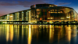 The European Union Parliament in Strasbourg, France, illuminated at night beside a body of water