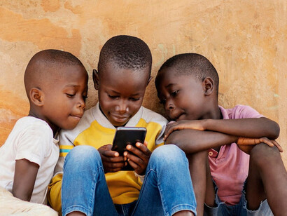 A young student uses a device to explore educational content, demonstrating the potential of digital tools to transform learning in underserved African communities