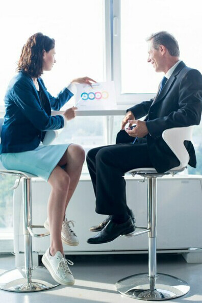 A coach explaining an infographic elements sheet to her client, illustrating the step-by-step process of the coaching journey, emphasizes the strategic planning and consistency required to overcome the challenges of entrepreneurship