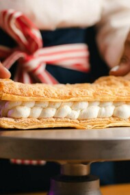 Un pâtissier prépare un dessert populaire, le mille-feuille