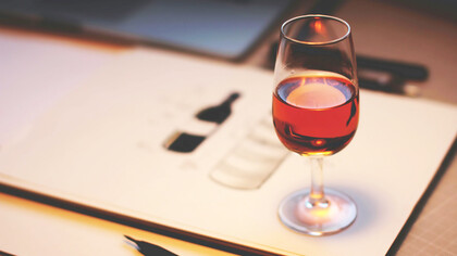 A glass of rich red wine sits elegantly on the table, adding a touch of sophistication to the scene